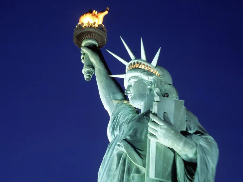A statue of liberty with the torch lit up.