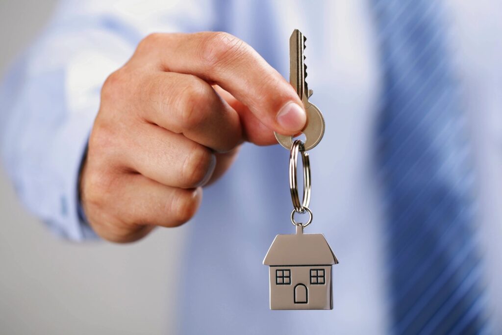 A person holding keys to a house.